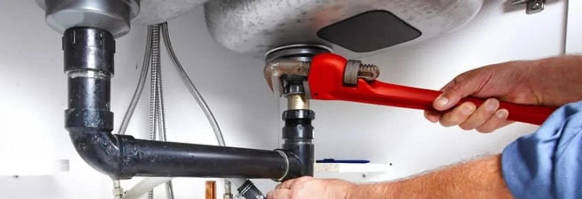 Garbage disposal repair technician tightening the sink drain and disposal connection in Columbia, SC
